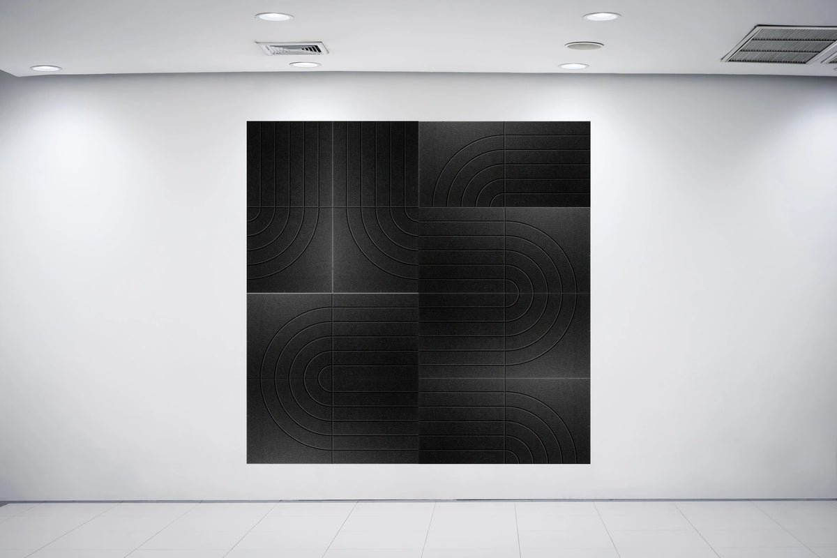 A large black square wall art piece with a subtle concentric circular pattern, mounted on a white gallery wall in a minimalist art space.