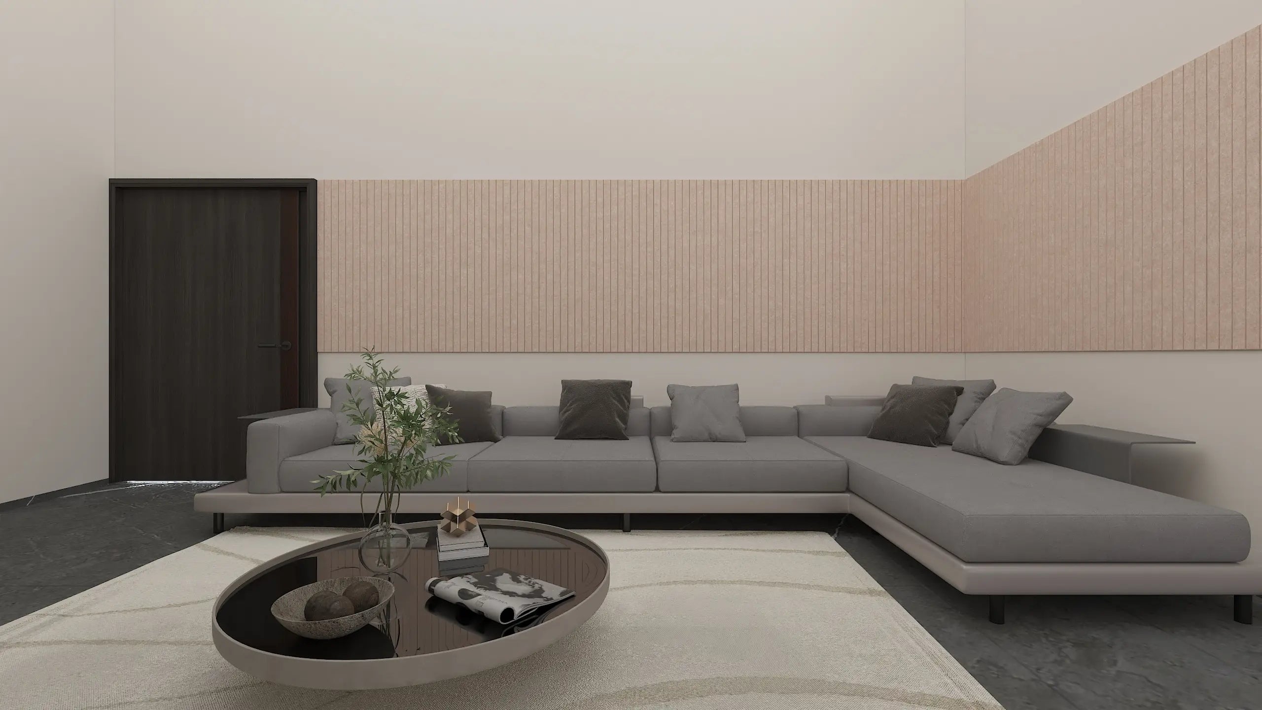 A modern gray sectional sofa with matching throw pillows in a minimalist living room setting, featuring a light wood slatted accent wall, a dark wood door, and a round coffee table on a white rug.