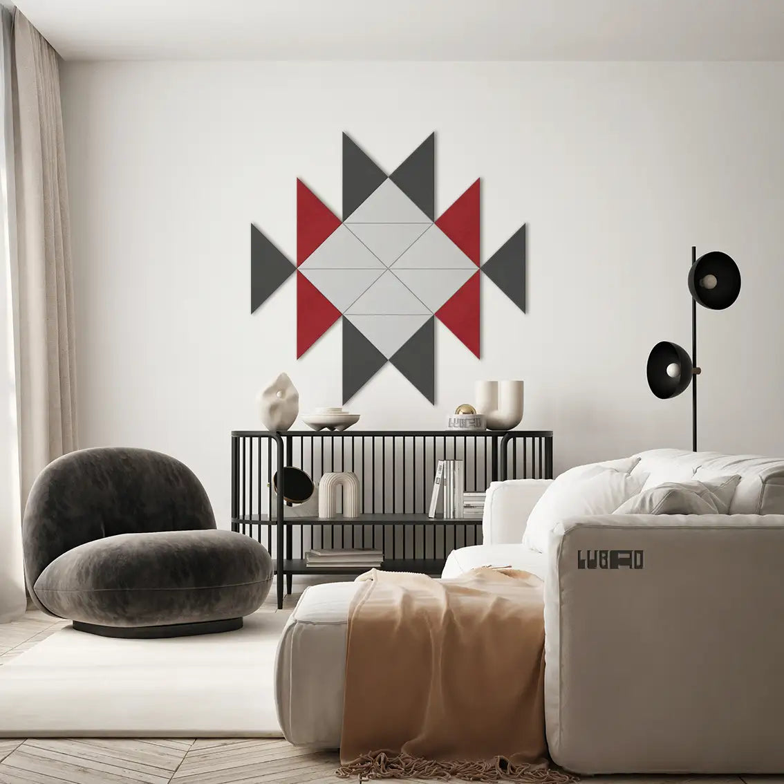 A geometric patterned wall panel in black, white, and red hanging on a white wall in a modern living room setting.