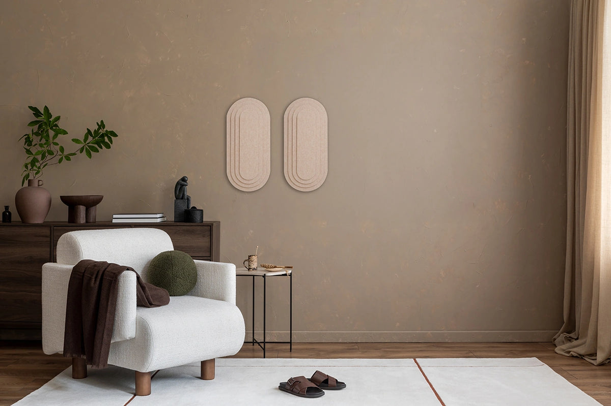 A room with 'Topo' 3D panels on the wall, a wooden table, a beige armchair, a standing lamp, and various decorative items.
