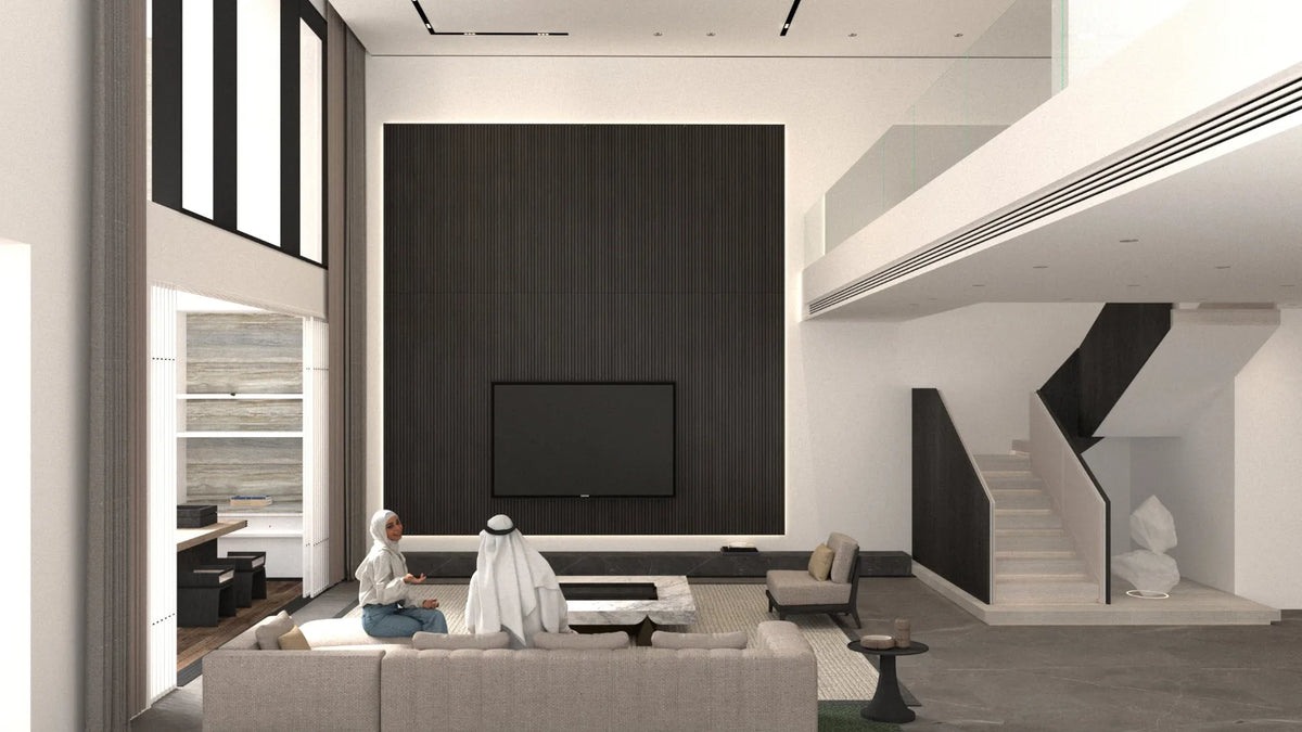 A modern, high-ceilinged living room with a large black wood accent wall, wall-mounted TV, staircase, and a light beige sectional sofa. Two people are seated on the sofa in the foreground.