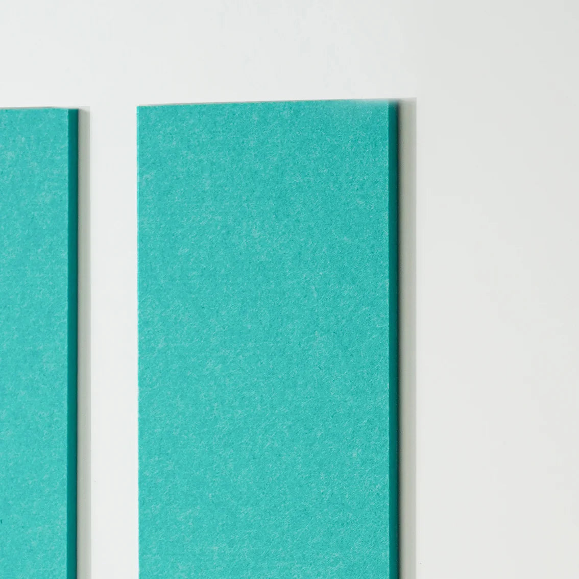A close-up of two vertical teal panels with a textured surface, shown against a plain white background.