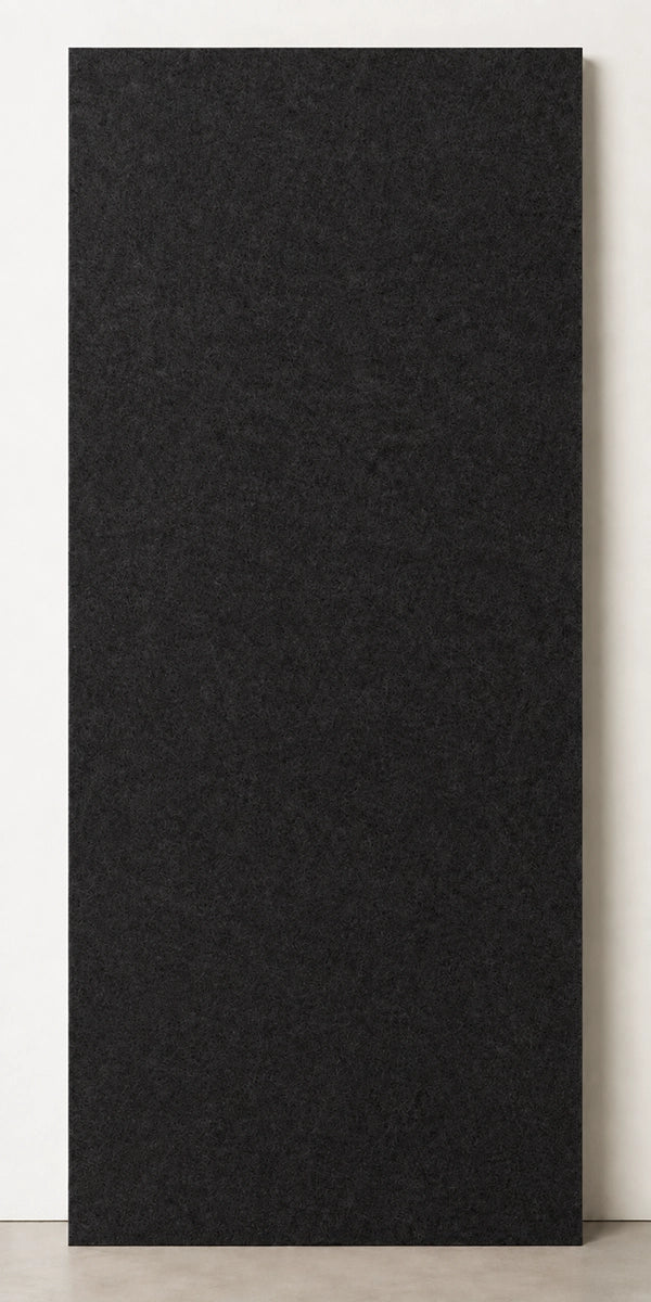 A tall, rectangular Black textured panel or board standing upright against a light neutral wall on a concrete floor.
