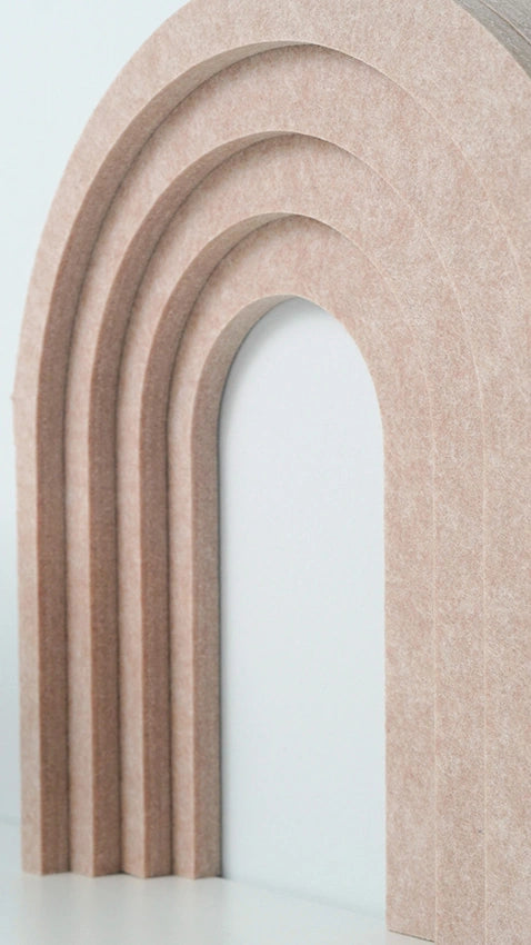 A decorative arch-shaped wall piece made of layered, ribbed beige material, shown against a clean white background.