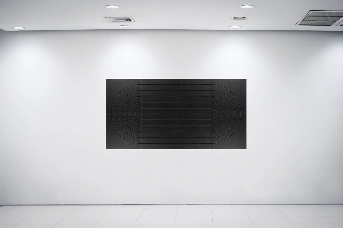 A minimalist black rectangular wall art piece with concentric oval line patterns, displayed on a clean white gallery wall under recessed ceiling lights.
