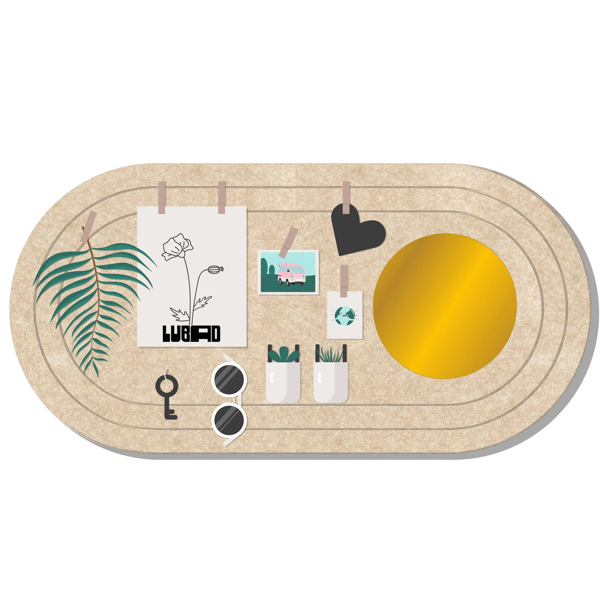 An oval beige desk organizer board with concentric rings, shown from above on a white background. The board is styled with clips, a palm leaf print, a flower illustration reading 'WEIRD', a black heart, a small landscape photo, two white cups with pens, sunglasses, a key, and a large gold circular accent.