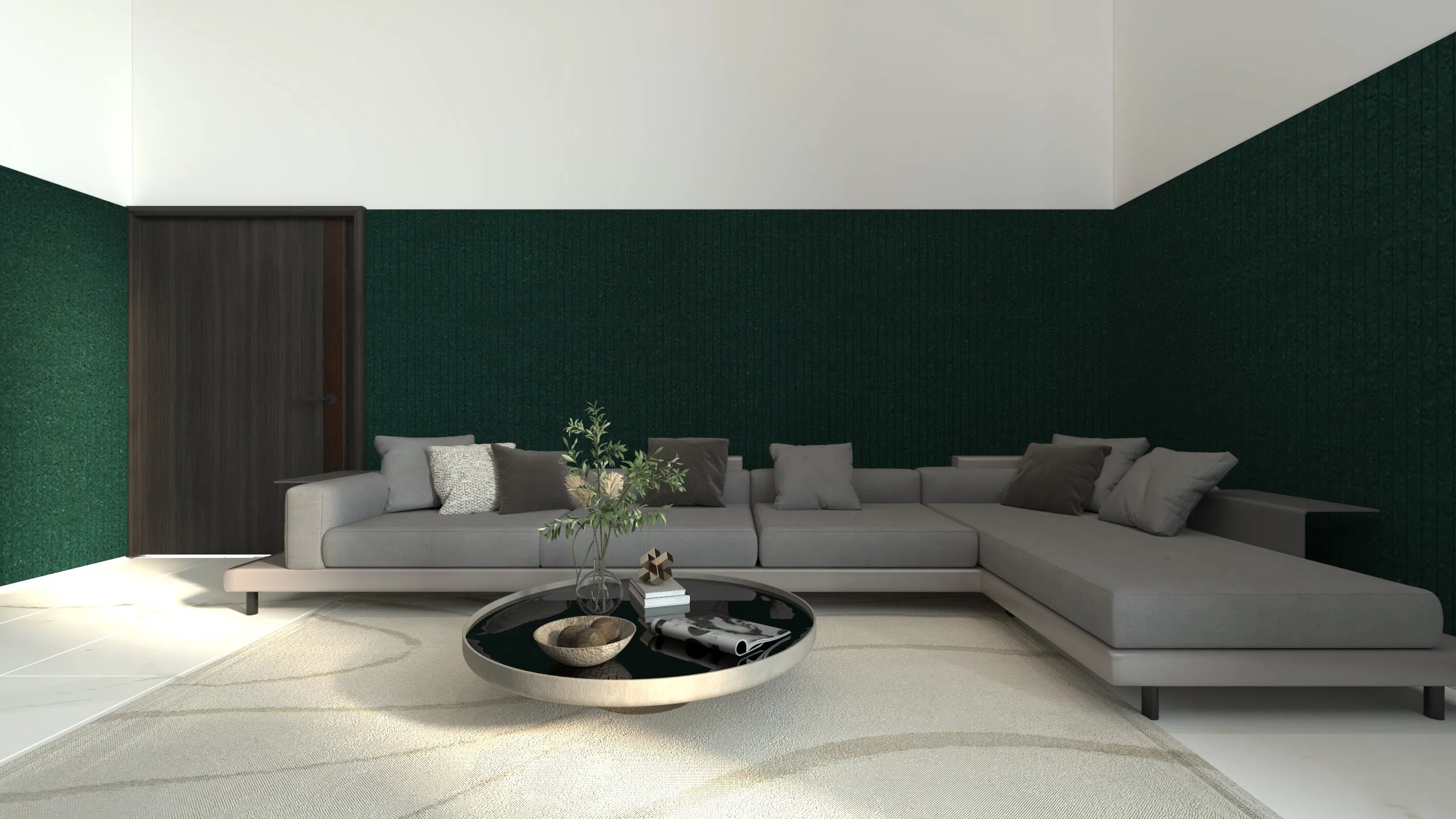 A modern gray sectional sofa with dark gray and white throw pillows, set in a minimalist living room with a dark green textured accent wall, a white rug, and a round black coffee table.