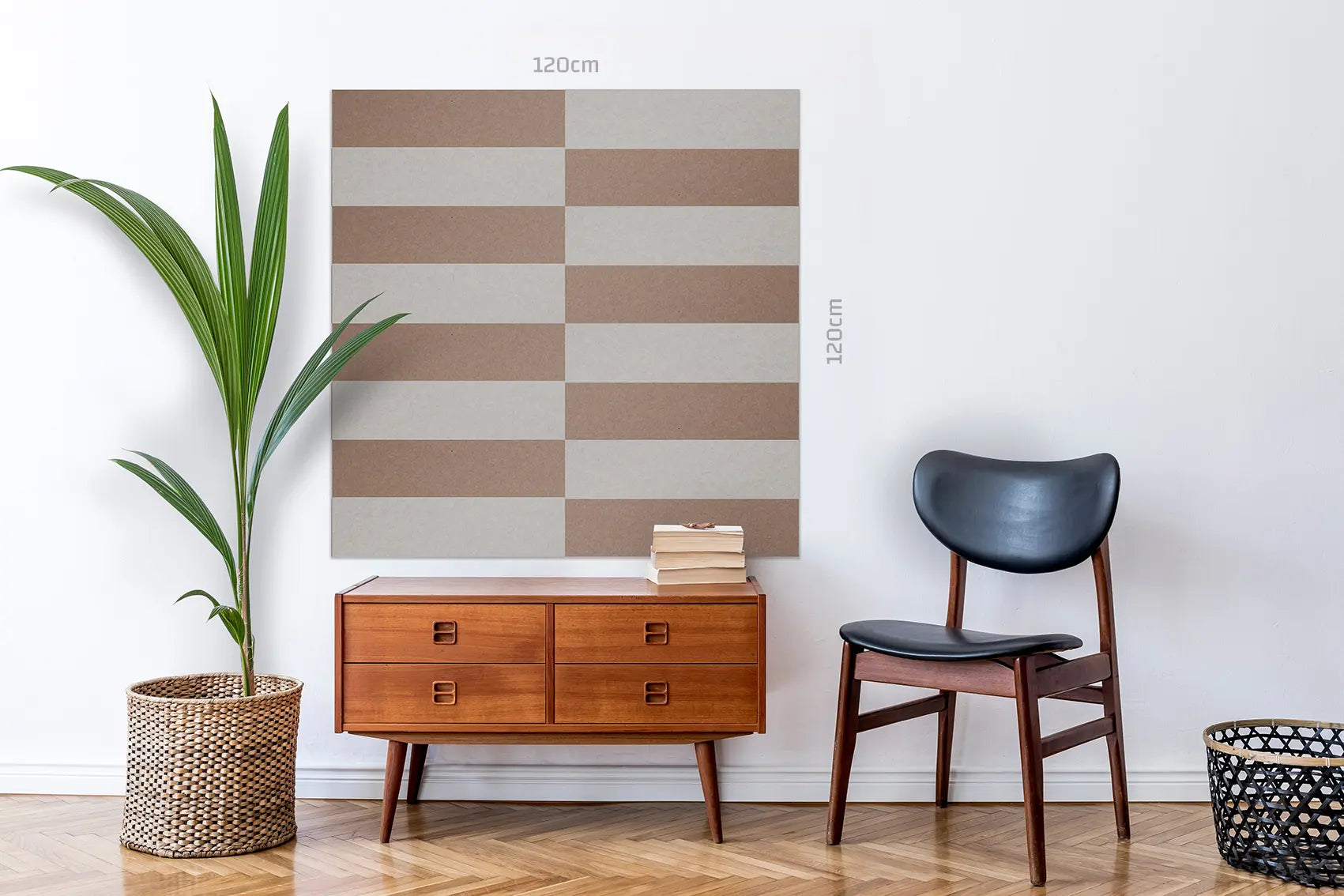 A large wall art piece with alternating beige and taupe-brown rectangular blocks, shown hanging on a white wall in a styled room with a wooden cabinet, chair, plant, and basket. The image includes dimension markers reading 120cm vertically and 120cm horizontally.
