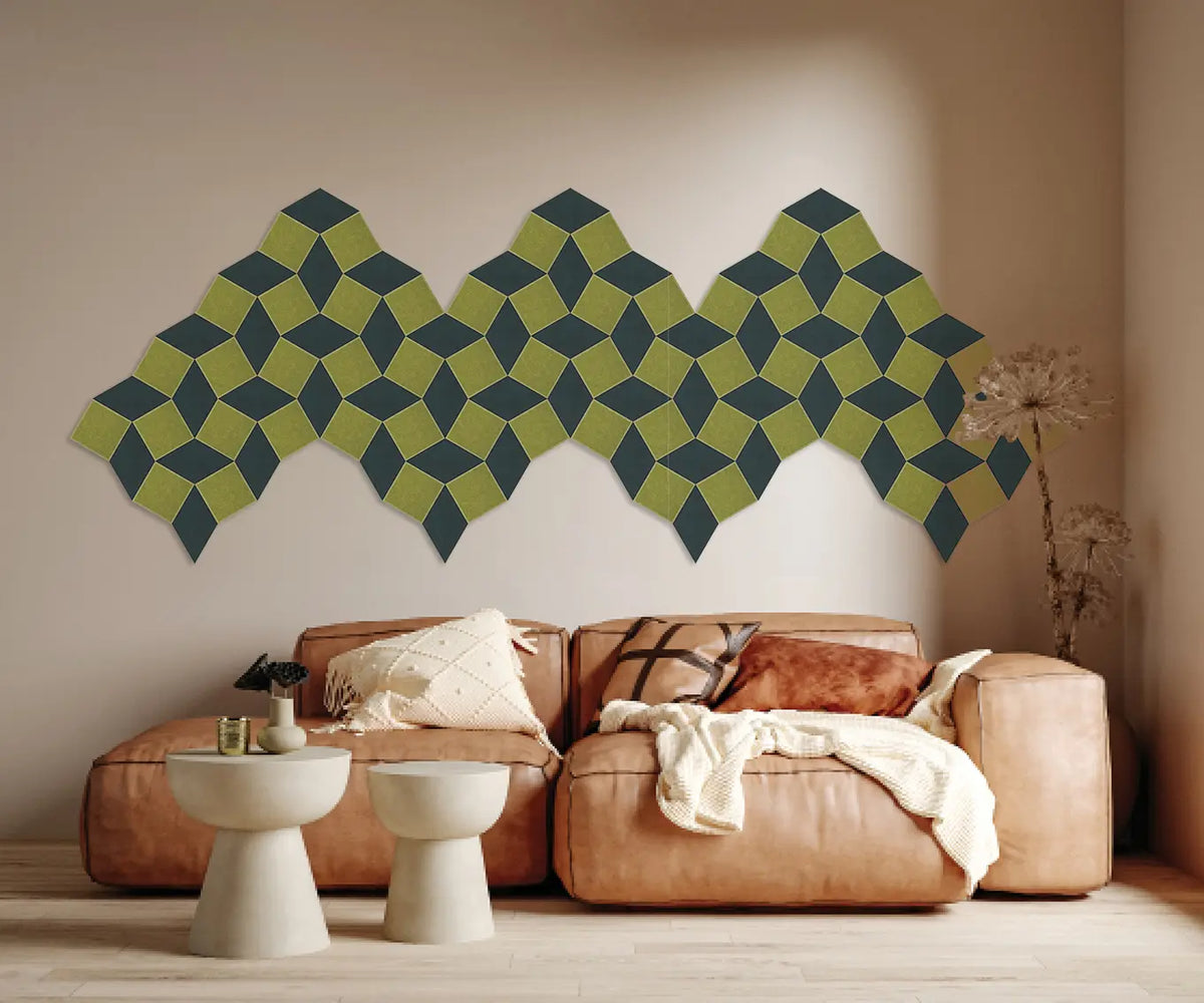 A modern living room scene featuring a large geometric wall art piece made of interlocking 3D cube shapes in olive green and dark teal, mounted on a beige wall above a tan leather sectional sofa.