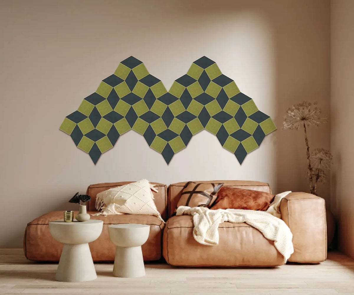 A modern living room scene featuring a set of geometric, mountain-shaped wall panels in olive green and dark gray above a tan leather sofa.
