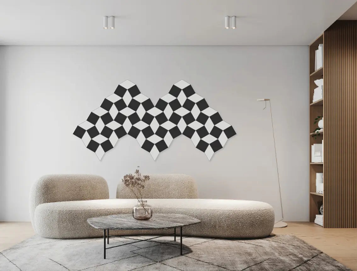 A modern living room featuring a black and white geometric cube-patterned wall art piece mounted on a light gray wall above a beige boucle sofa.