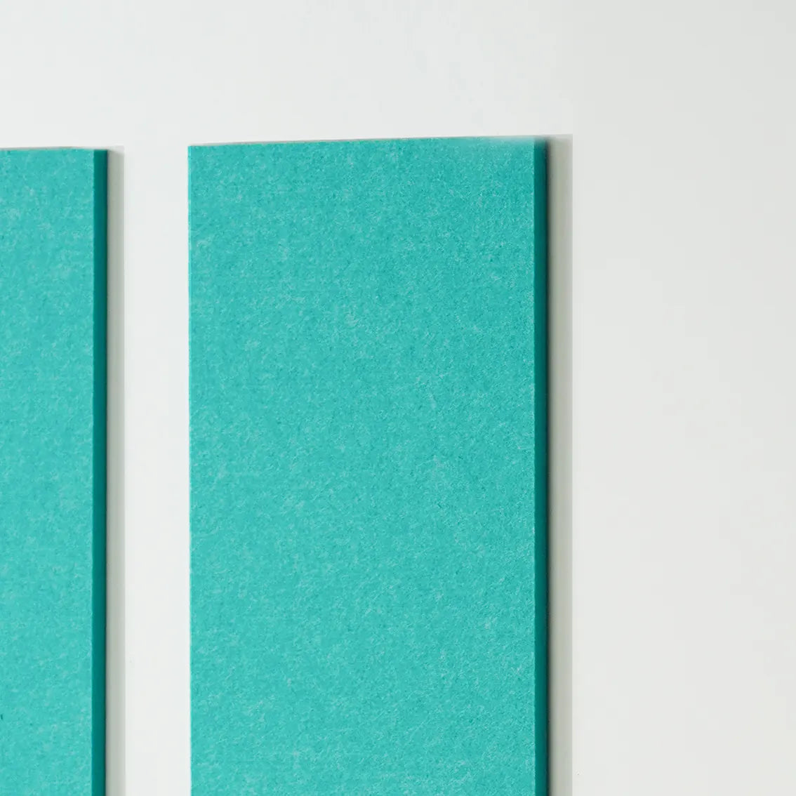 A close-up of two vertical teal panels with a textured surface, shown against a plain white background.
